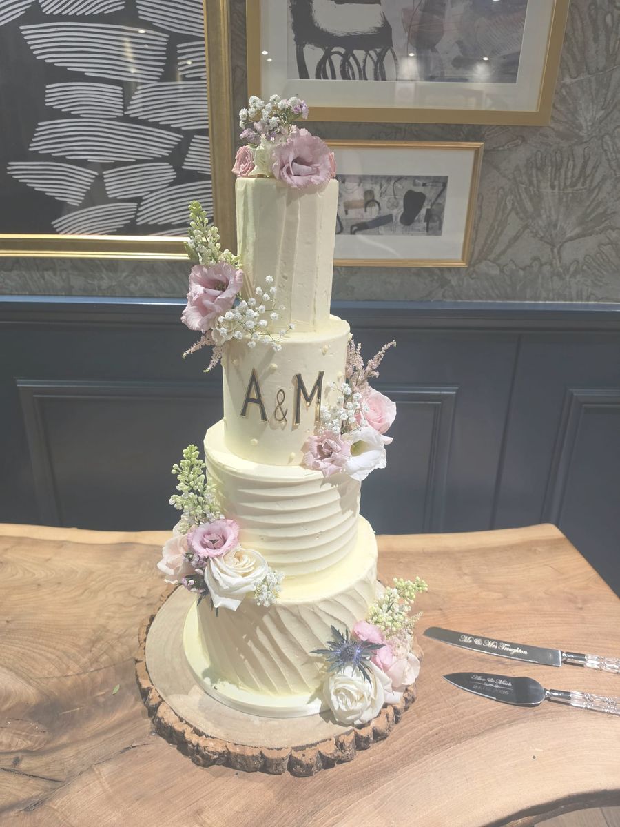 Four tier buttercream cake with pink fresh flowers