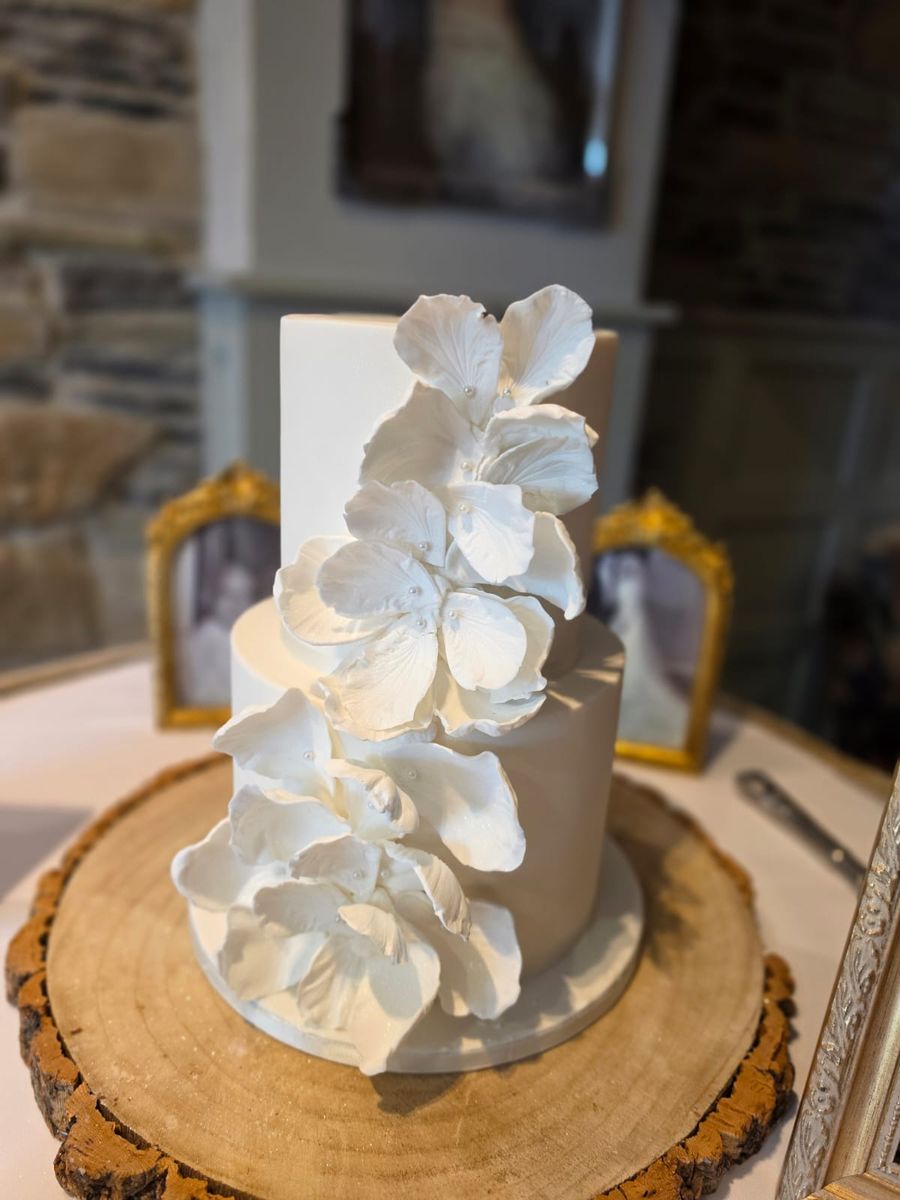Two tier white cake with a cascade of sugar petals