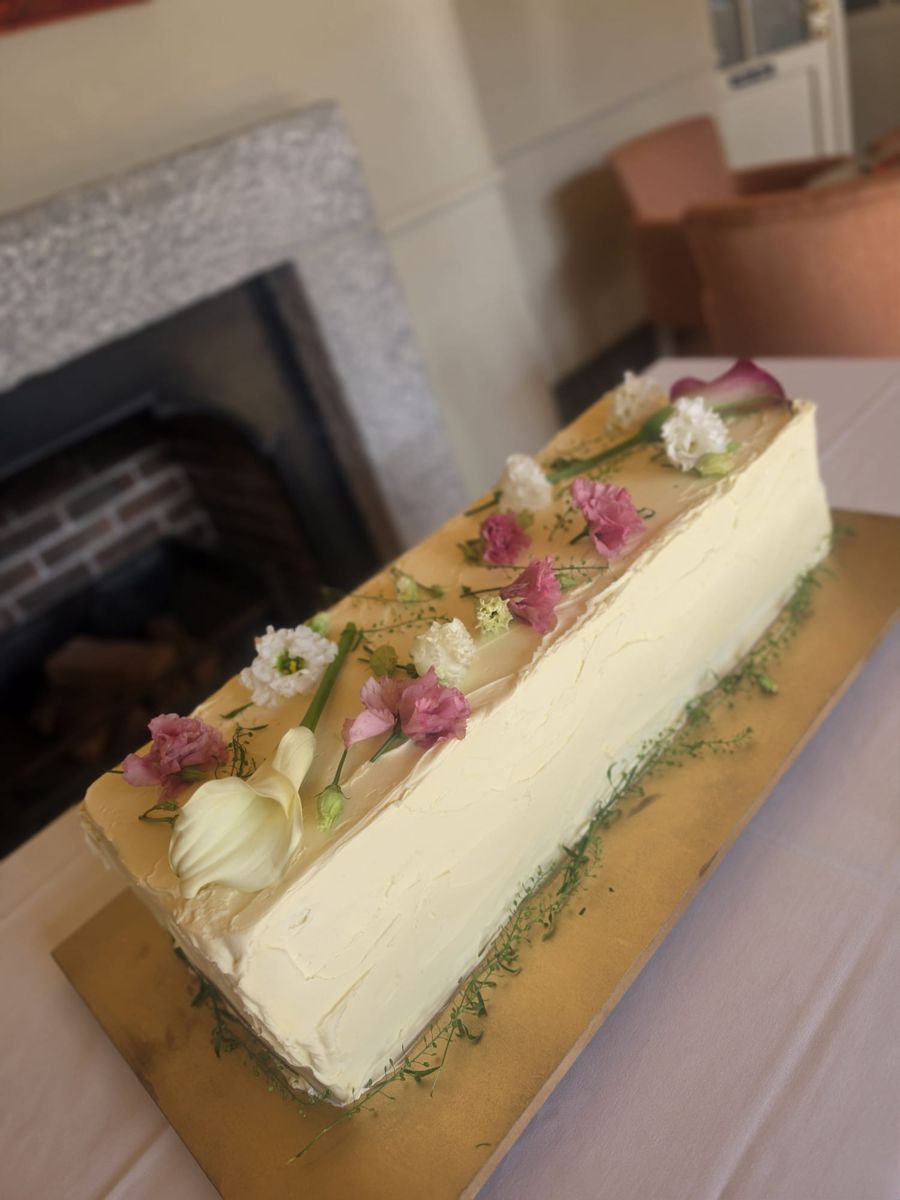 Rustic buttercream table cake topped with fresh calla lilies and pink carnations