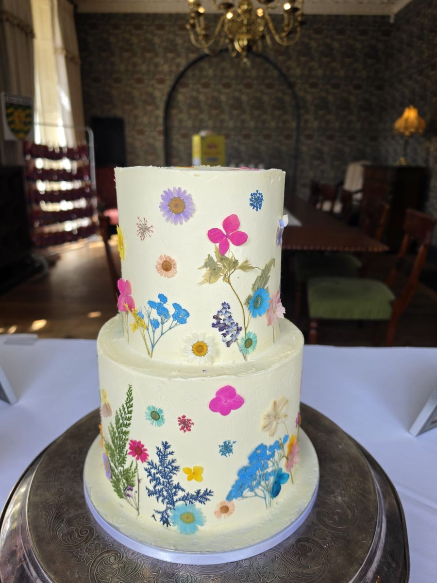 Two tier buttercream cake with pressed wildflowers